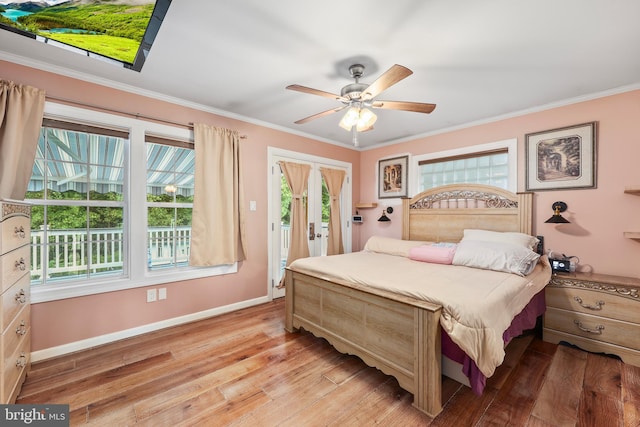 bedroom featuring ceiling fan, crown molding, light hardwood / wood-style flooring, and multiple windows