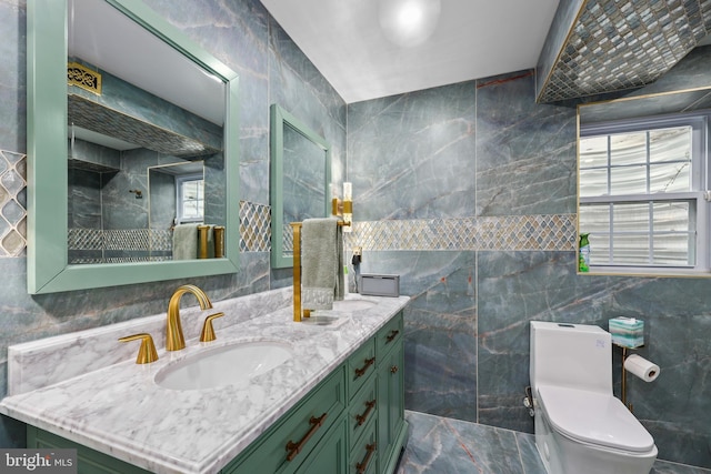 bathroom with vanity, tile walls, and toilet