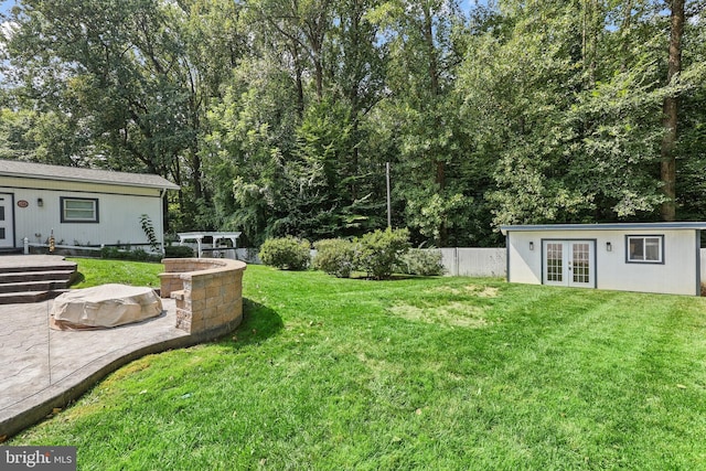 view of yard with a patio, an outdoor fire pit, and french doors