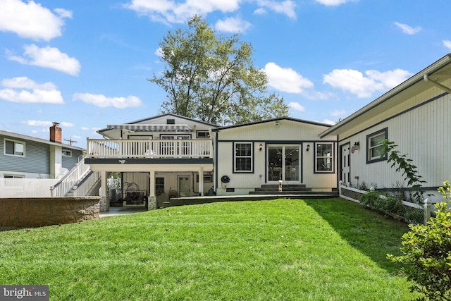 rear view of house featuring a yard, a patio, and a wooden deck