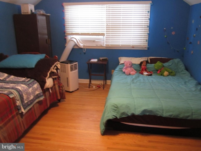 bedroom featuring vaulted ceiling and light hardwood / wood-style flooring