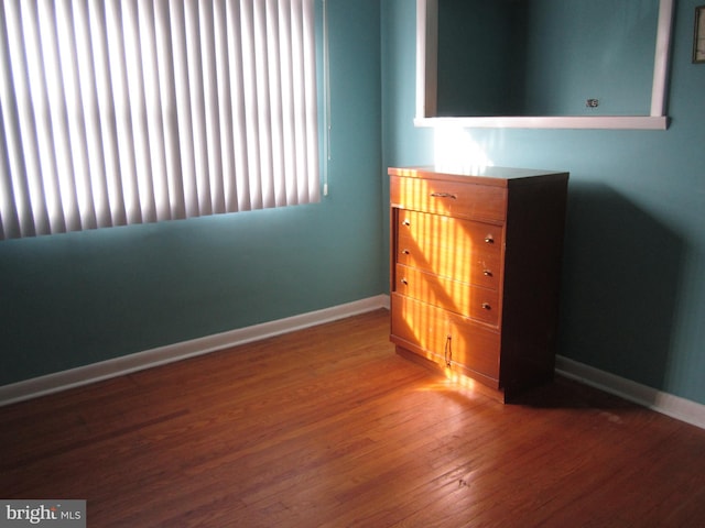 unfurnished bedroom featuring hardwood / wood-style flooring and multiple windows