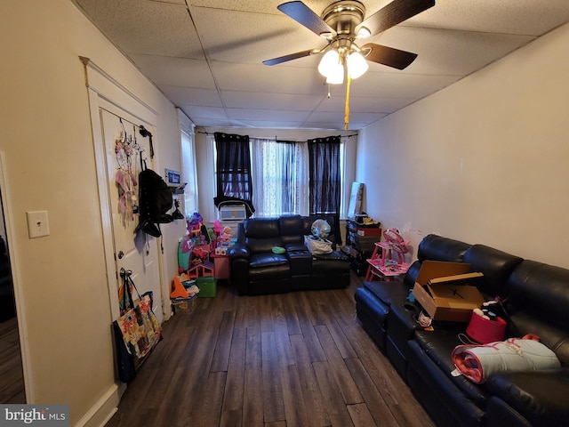 recreation room with ceiling fan, a drop ceiling, and dark hardwood / wood-style floors