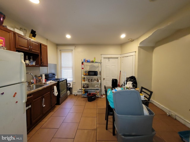 kitchen with sink, light tile patterned floors, and black appliances