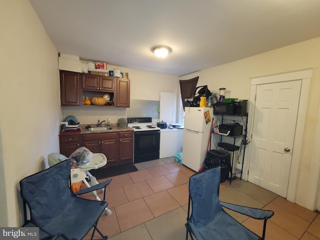 kitchen with dark tile patterned floors, white appliances, and sink