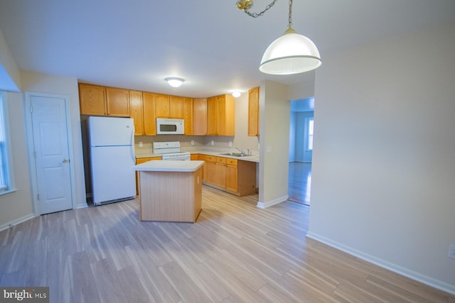 kitchen with white appliances, sink, hanging light fixtures, light wood-type flooring, and a kitchen island