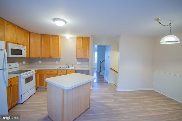 kitchen featuring pendant lighting, white appliances, light hardwood / wood-style floors, and a kitchen island