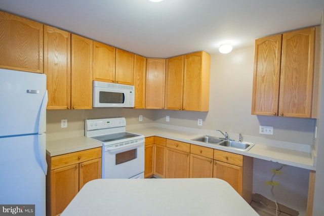 kitchen with light brown cabinetry, sink, and white appliances