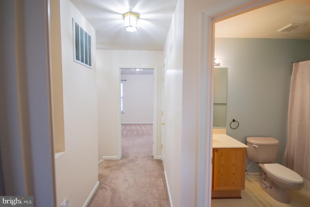 hall with light colored carpet