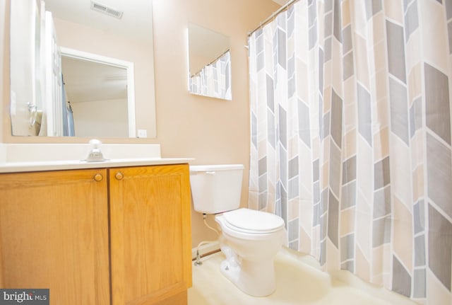 bathroom featuring vanity, toilet, and curtained shower