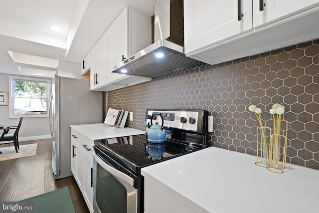 kitchen featuring decorative backsplash, dark hardwood / wood-style flooring, wall chimney exhaust hood, stainless steel appliances, and white cabinetry