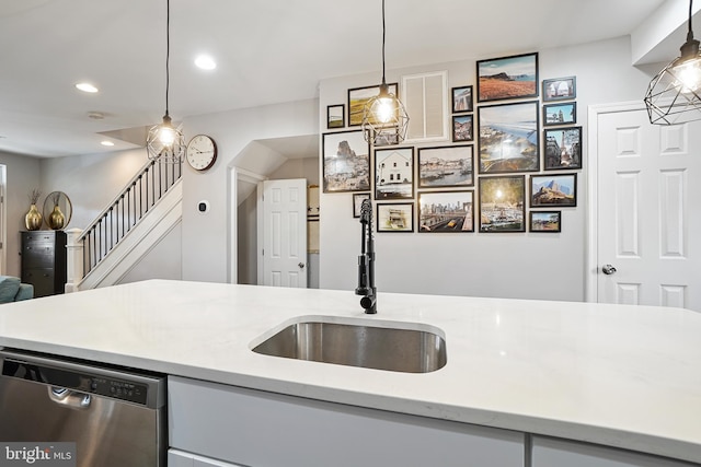 kitchen featuring decorative light fixtures, stainless steel dishwasher, and sink