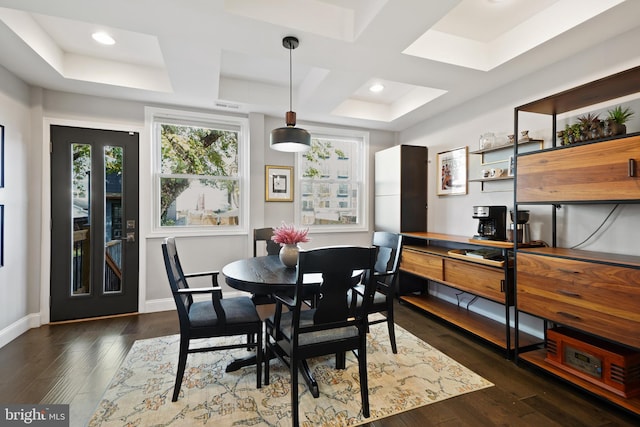 dining space with coffered ceiling and dark hardwood / wood-style floors