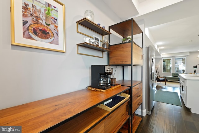 kitchen with white cabinetry, dark wood-type flooring, and stainless steel refrigerator with ice dispenser