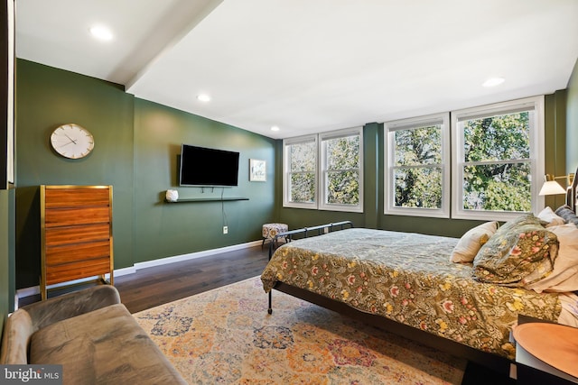 bedroom with multiple windows and dark wood-type flooring