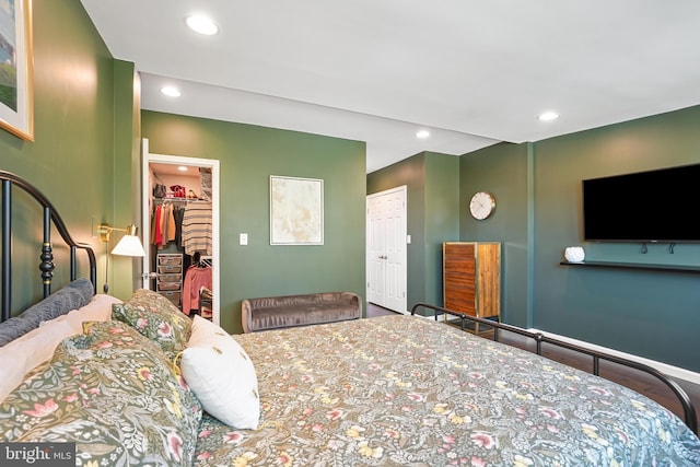 bedroom featuring hardwood / wood-style flooring, a spacious closet, and a closet