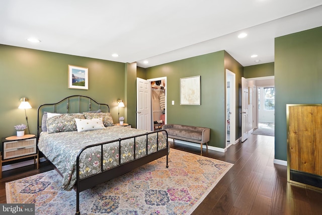 bedroom featuring dark hardwood / wood-style flooring, a spacious closet, and a closet