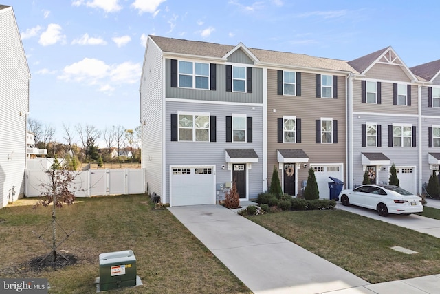 view of property with a garage and a front lawn