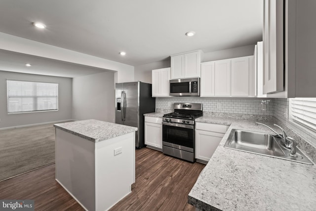 kitchen featuring sink, a center island, dark hardwood / wood-style flooring, white cabinets, and appliances with stainless steel finishes