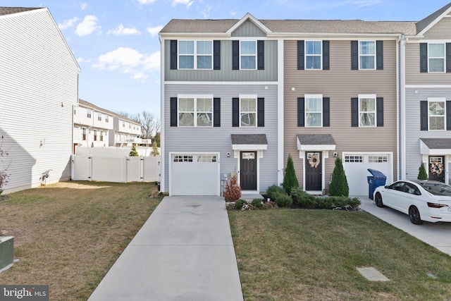 view of property with a garage and a front lawn