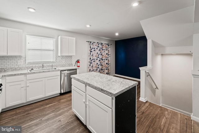 kitchen featuring stainless steel dishwasher, a kitchen island, white cabinetry, and dark wood-type flooring