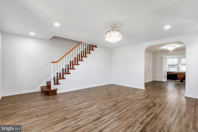 unfurnished living room featuring hardwood / wood-style floors and a notable chandelier