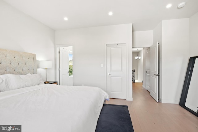 bedroom with light wood finished floors and recessed lighting