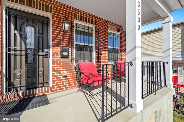 entrance to property featuring brick siding and a porch