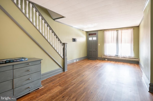 foyer entrance featuring crown molding, wood-type flooring, and baseboard heating