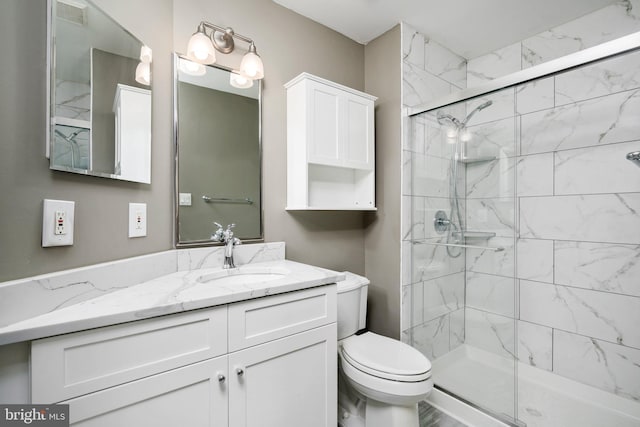 bathroom featuring vanity, toilet, and walk in shower