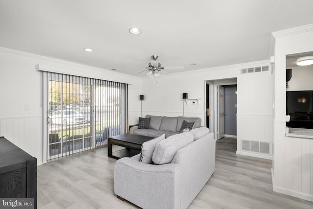 living room featuring light hardwood / wood-style floors, ceiling fan, and crown molding