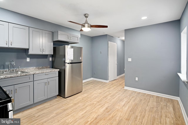 kitchen featuring sink, ceiling fan, gray cabinets, light wood-type flooring, and appliances with stainless steel finishes