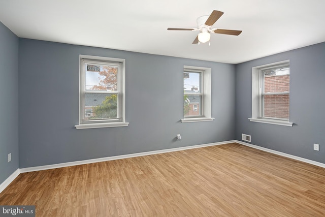 spare room with light hardwood / wood-style floors, plenty of natural light, and ceiling fan