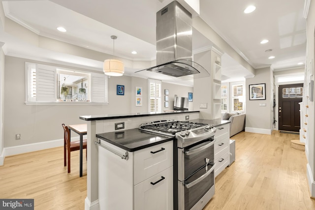 kitchen with white cabinetry, stainless steel gas stove, island exhaust hood, pendant lighting, and light wood-type flooring