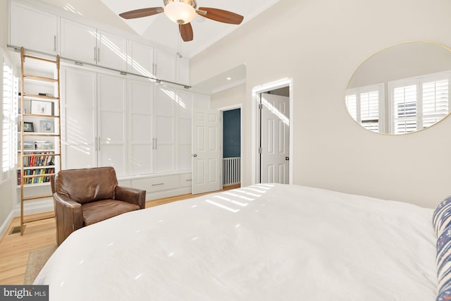 bedroom with ceiling fan, light hardwood / wood-style flooring, crown molding, and vaulted ceiling