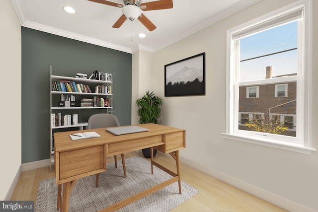 office featuring a healthy amount of sunlight, ornamental molding, and light hardwood / wood-style flooring