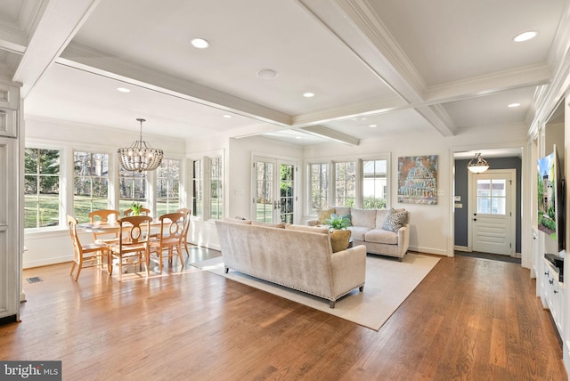 living area with a wealth of natural light, light wood-style flooring, and beam ceiling