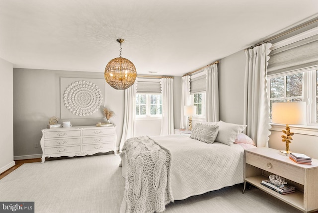 bedroom with a chandelier and baseboards