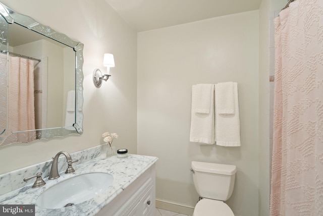 full bath with baseboards, vanity, and toilet