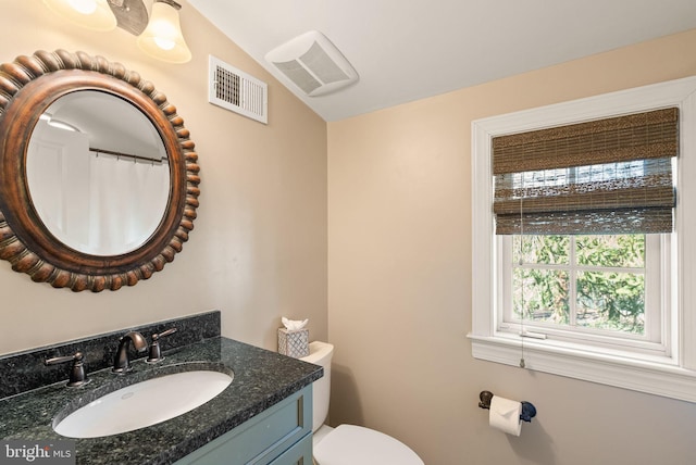 bathroom featuring toilet, lofted ceiling, visible vents, and vanity