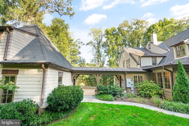 exterior space with metal roof, a standing seam roof, and a front yard