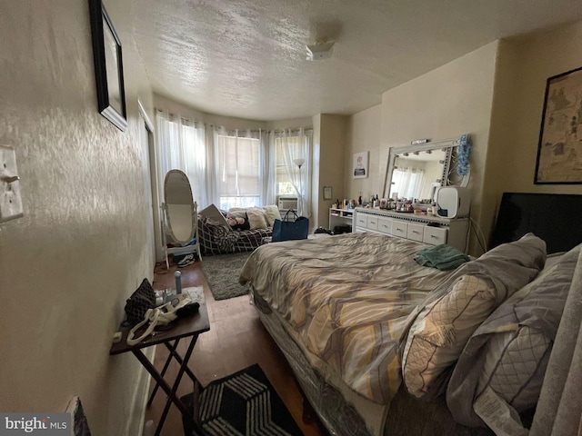 bedroom with a textured ceiling and light hardwood / wood-style flooring