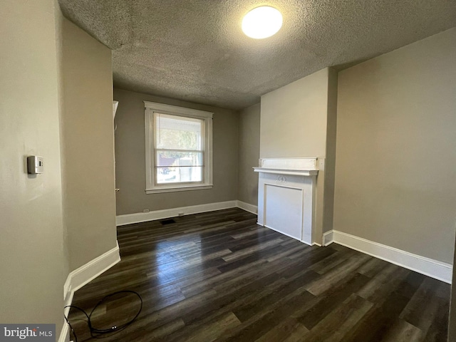 interior space with a textured ceiling and dark wood-type flooring