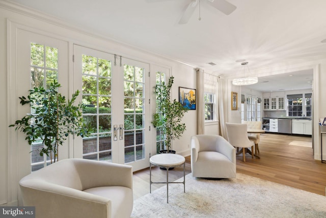 sitting room with ceiling fan, ornamental molding, light hardwood / wood-style floors, and french doors