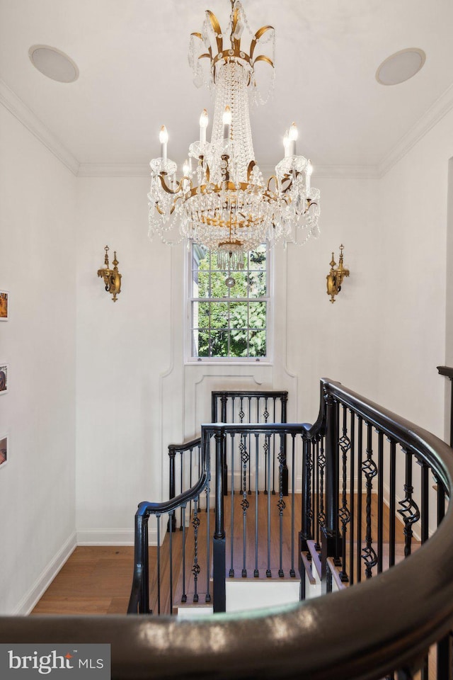 stairway featuring an inviting chandelier, crown molding, and hardwood / wood-style flooring