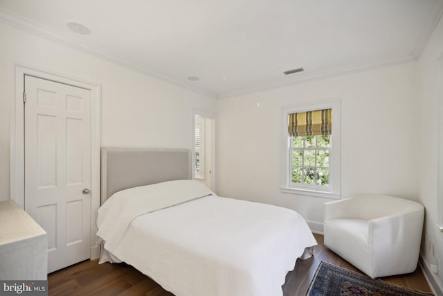 bedroom with dark wood-type flooring and crown molding