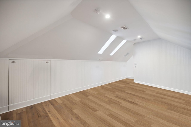 bonus room with lofted ceiling and hardwood / wood-style floors