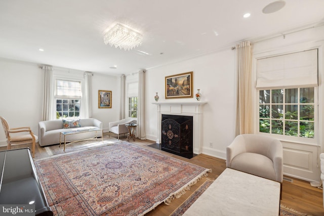 living room with a chandelier, dark hardwood / wood-style floors, and ornamental molding