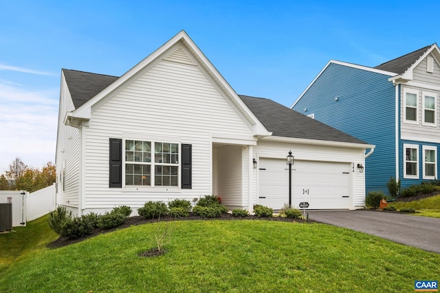 view of front of home featuring cooling unit, a garage, and a front lawn