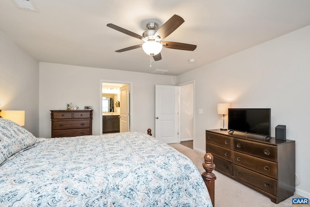 bedroom with connected bathroom, ceiling fan, and light colored carpet